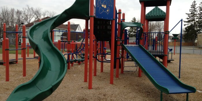 Photo of playground with multiple slides, decks, and climbers.