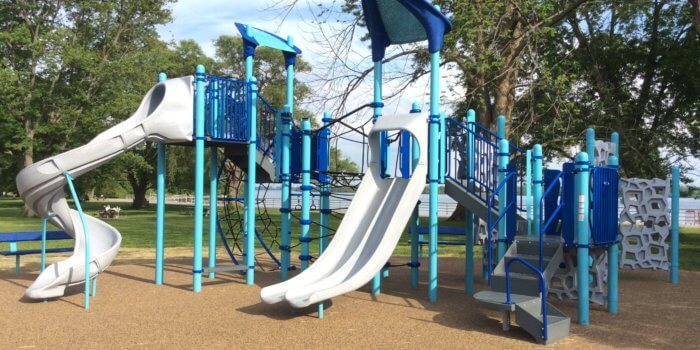 Photo of a play structure with several slides, decks, and climbing components
