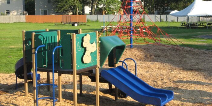 Photo of a smallplay structure for ages 2-5 with a rope climbing structure in the background