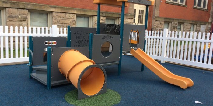Photo of small play structure with multilevel decks, a tunnel, and a slide