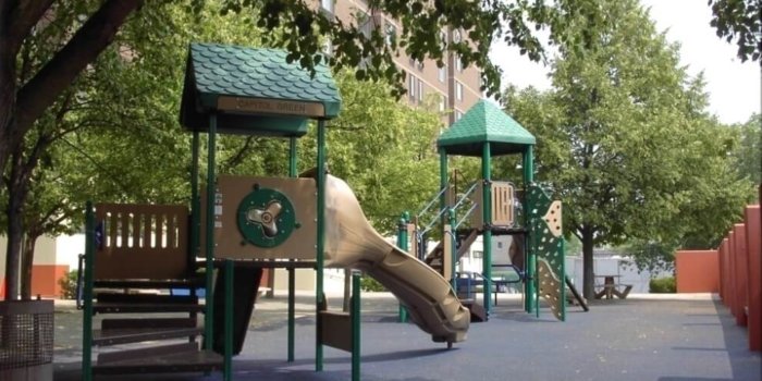 Photo of playgrounhd with slides, climbers, and play panels.