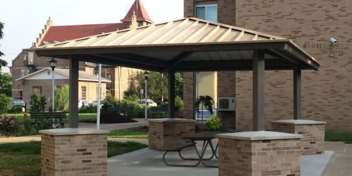Photo of square outdoor shelter with stone column wrappers.