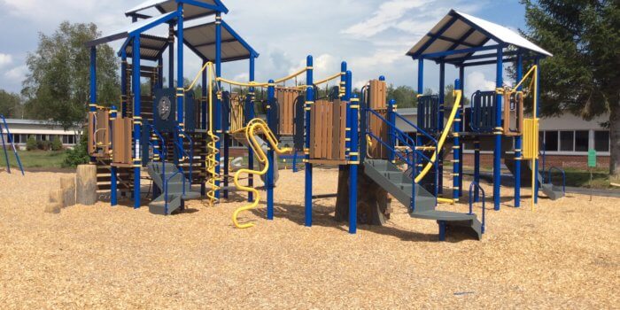 Photo of play structure with bridges, play panels, climbers, slides, and independent components