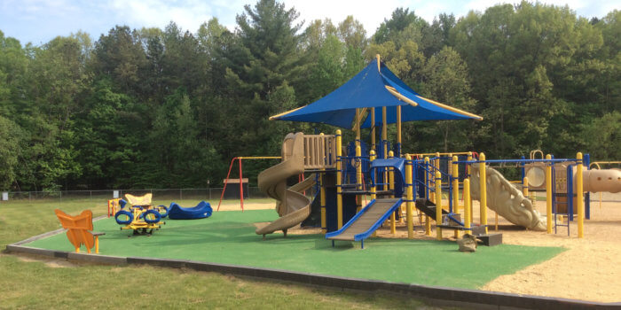 Photo of large shaded play structure with independent components surrounding it