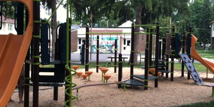 Photo of playground with multiple slides, climbers, bridges, and a balance beam.
