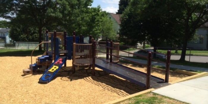 Photo of playground with wheelchair ramp, climbers, and a slide.