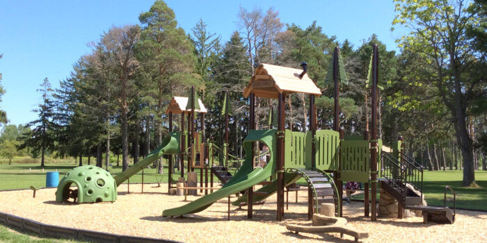 Photo of playground with slides, climbers, and sensory dome shelter.