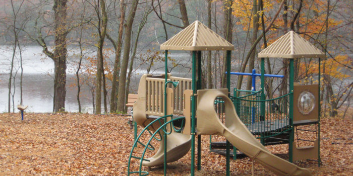 Photo of play structure with decks, roofs, climbers, slides, and a bridge