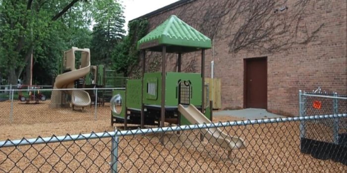 Photo of playground with slides, climbers, and play panels.