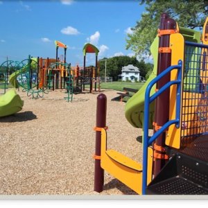 Photo of playground with climbing structures, slides, a spinner, and multiple levels of decks.