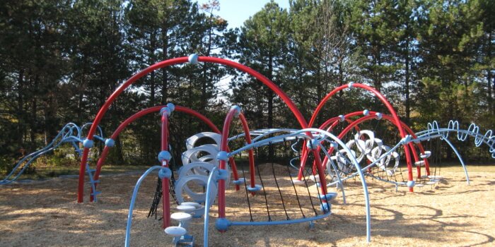 Photo of play structure with ground-to-ground arches with climbers, nets, and bridges