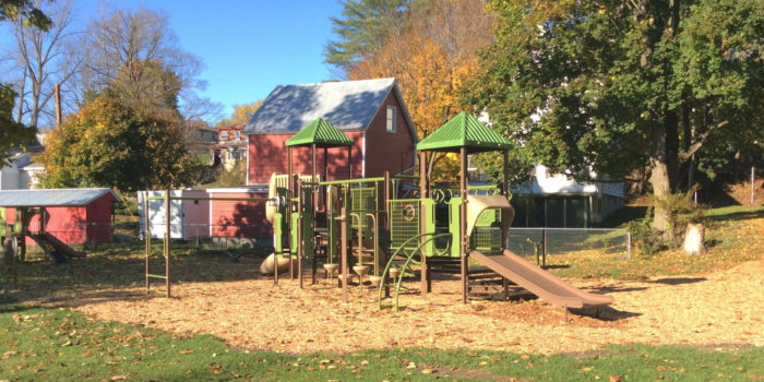 Photo of playground with slides, climbers, roofs, and swings.