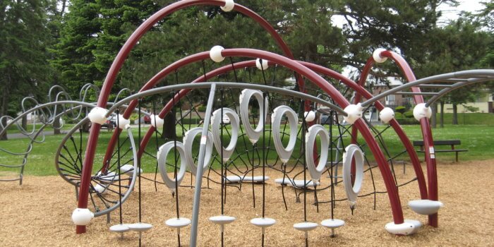 Photo of curved play structure with climbers and step bridges.