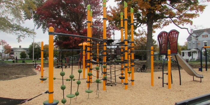 Photo of playground with multi-post net structure, climbers, and slides.