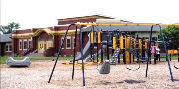Photo of playground with swings, climbers, slides, and a large spinner.